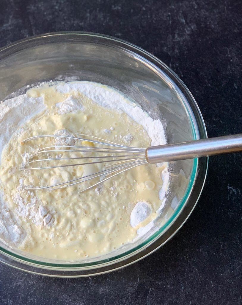 wet and dry ingredients combined with a whisk in a clear bowl