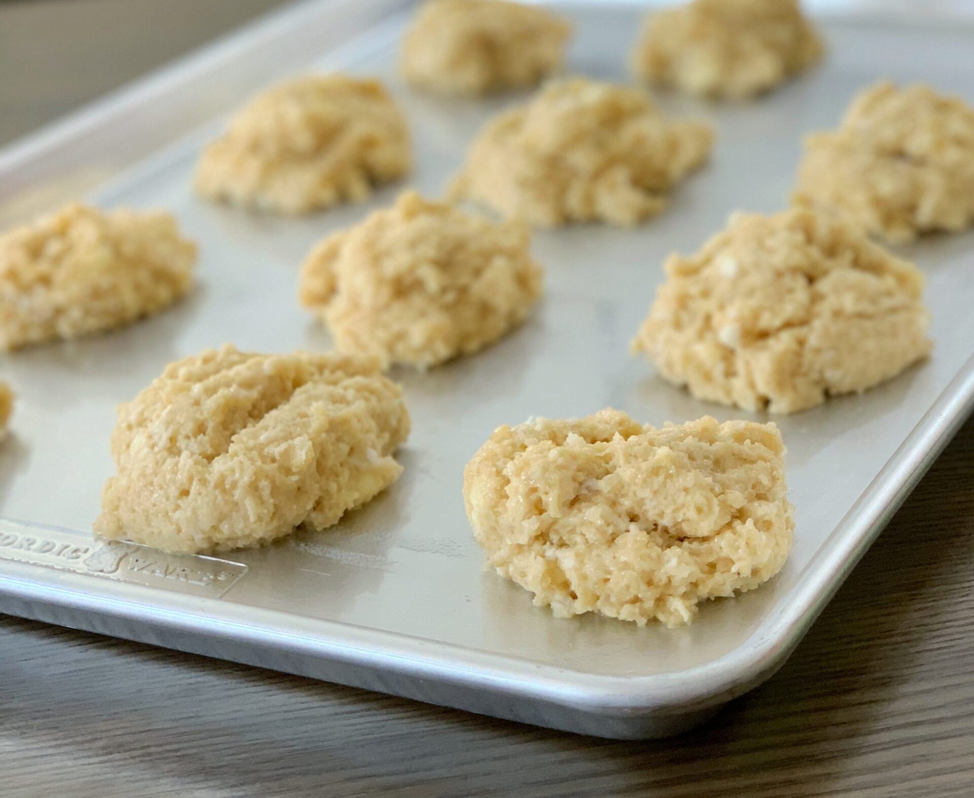 Guyanese coconut buns on a cookie sheet on a wooden counter