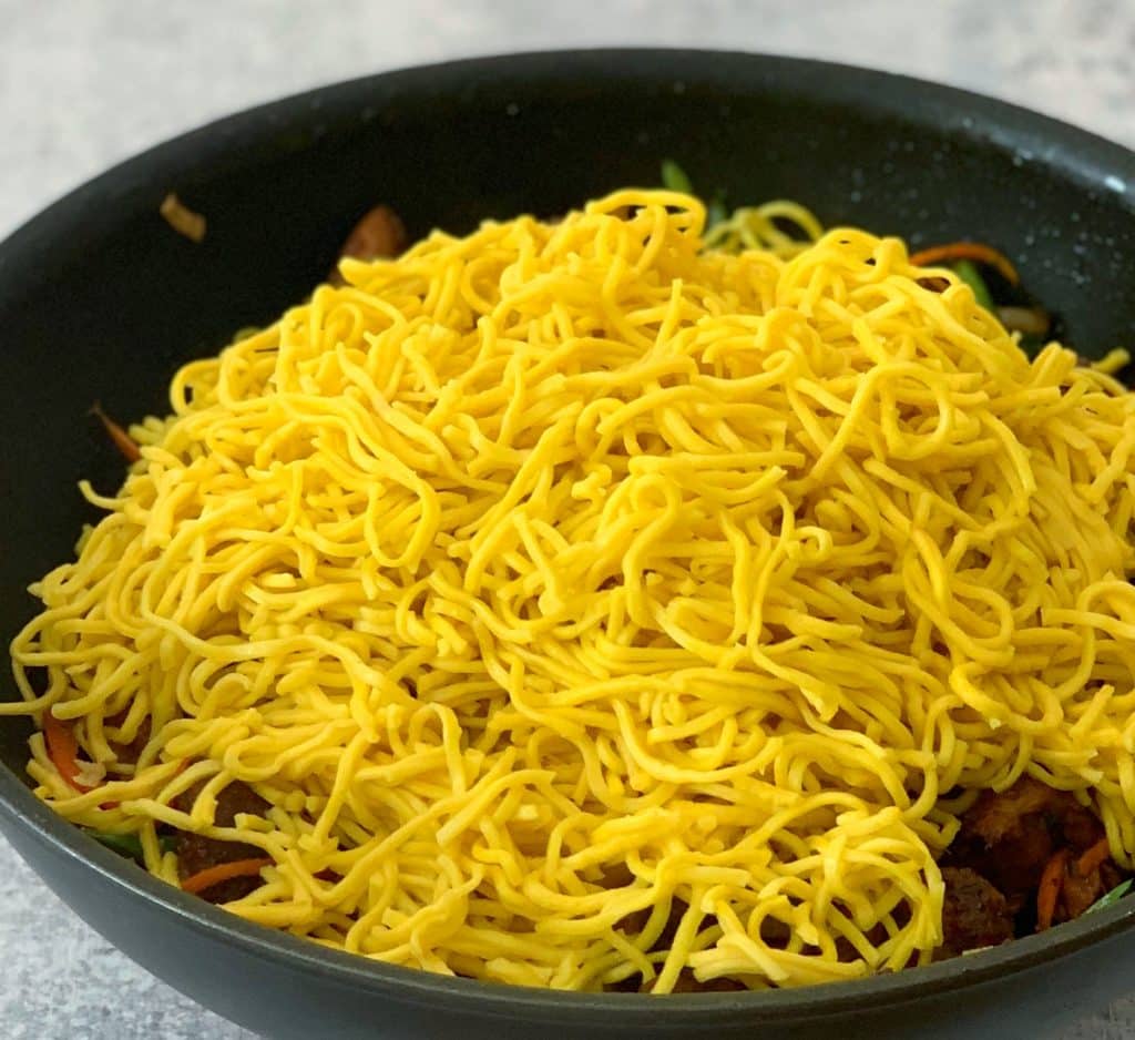 chow mein noodles added to a pan
