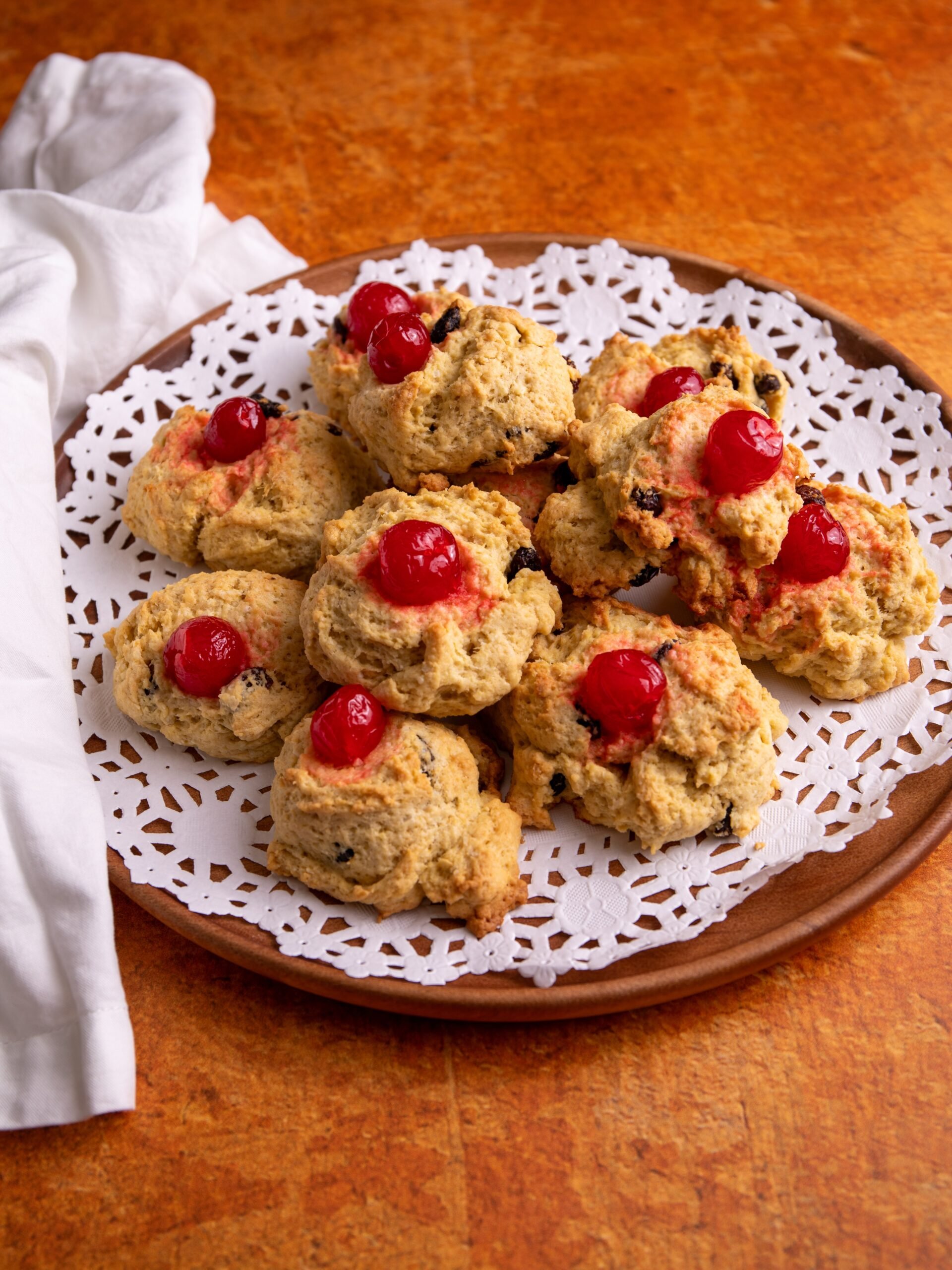 Guyanese coconut buns on a brown plate with a white doily