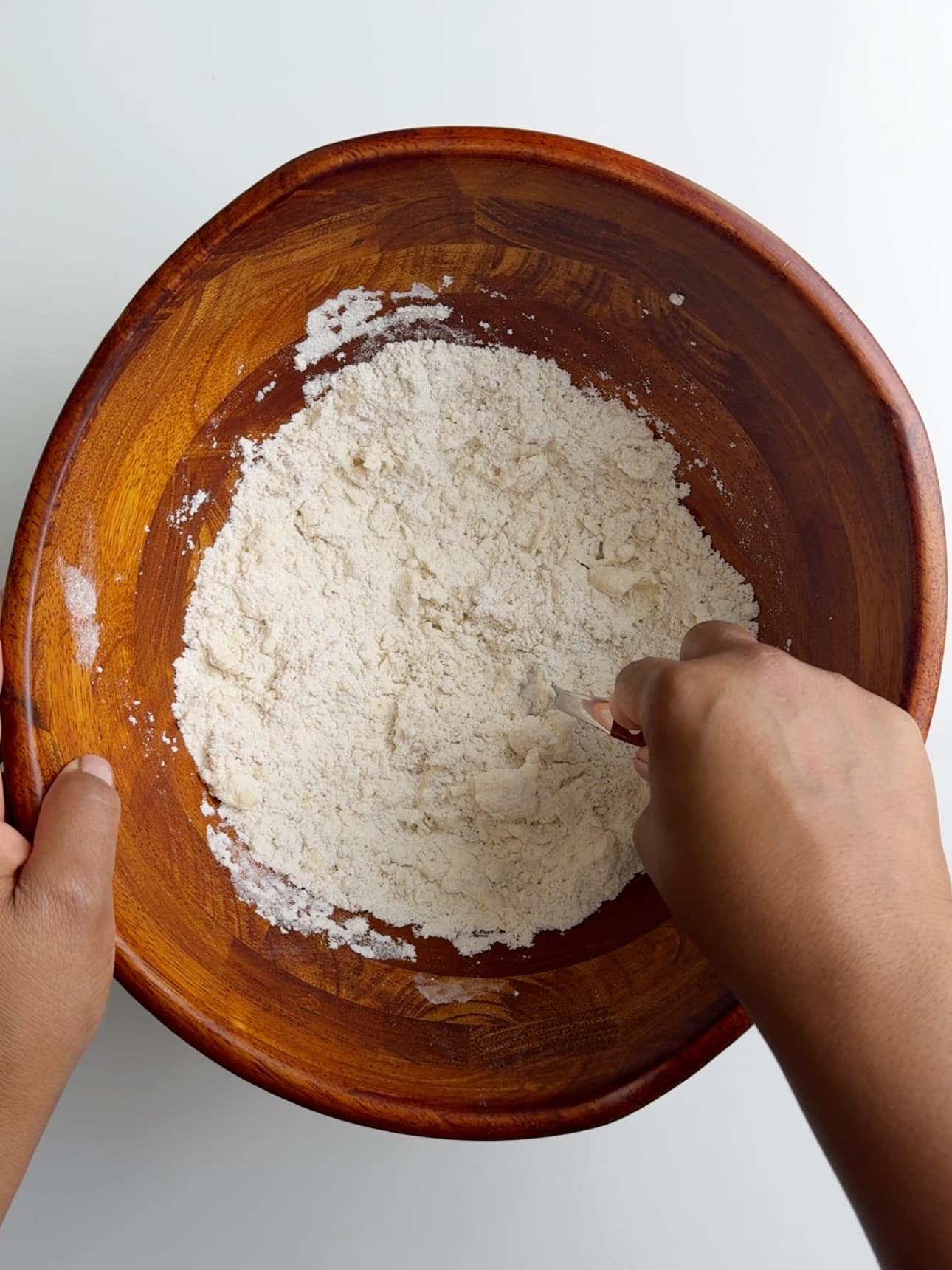 Rubbing butter into the dry ingredients to make coconut buns. 