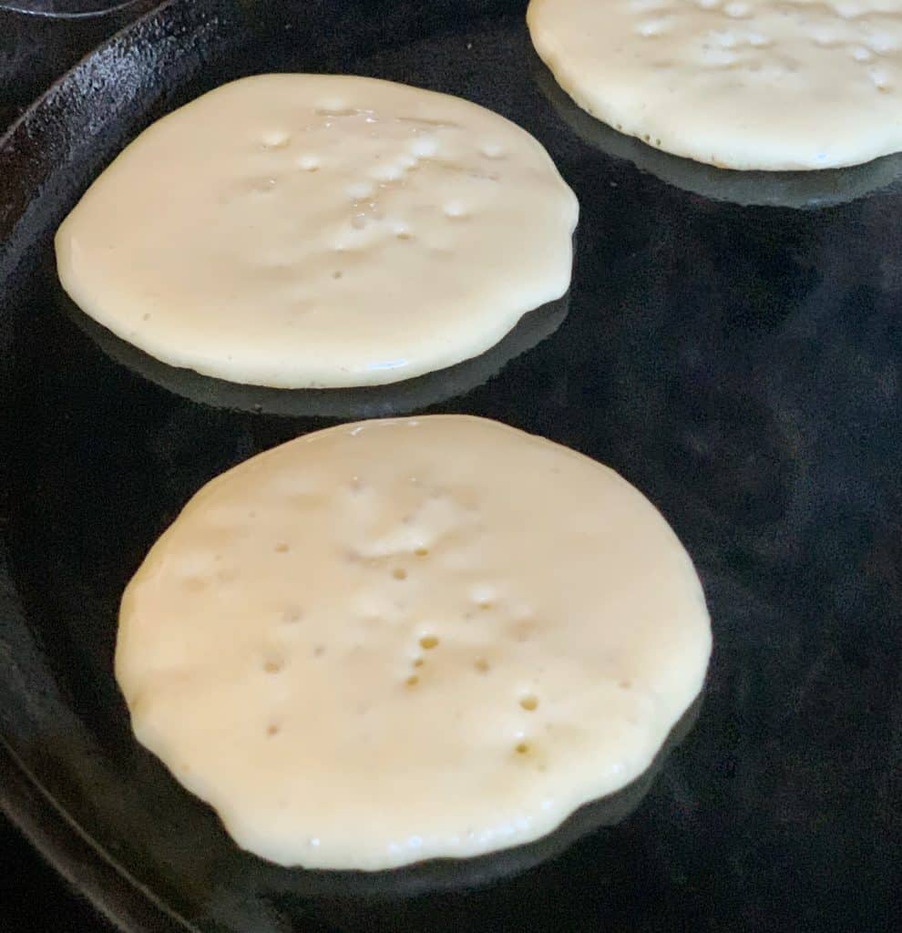 pancakes cooking on a griddle