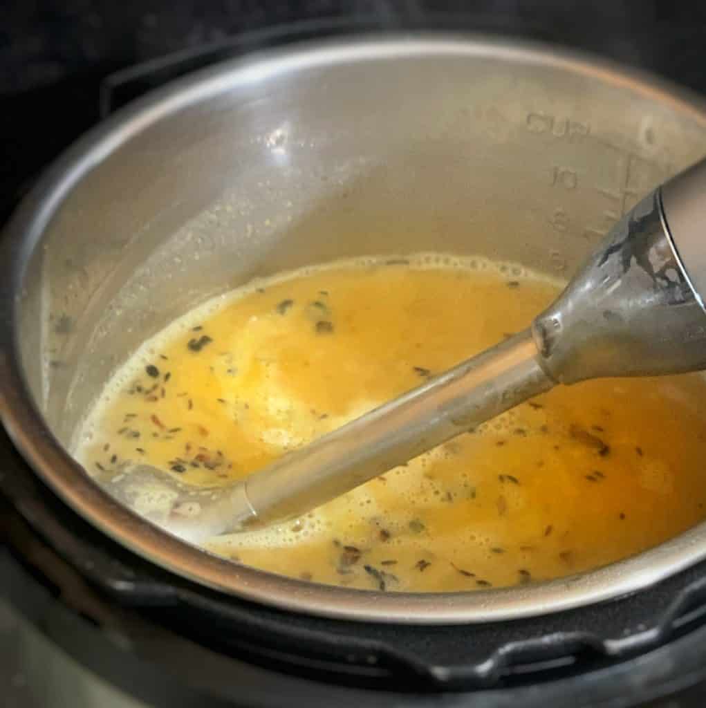 an immersion blender in a pot of dhal