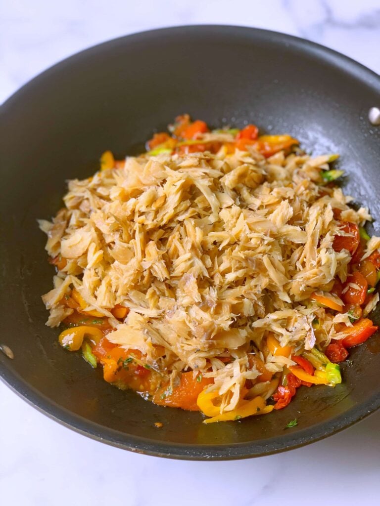 saltfish added to pan with sautéed veggies