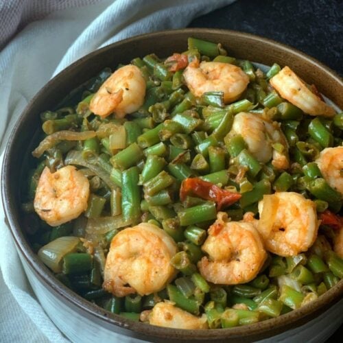 a bowl of shrimp and green beans stir fry