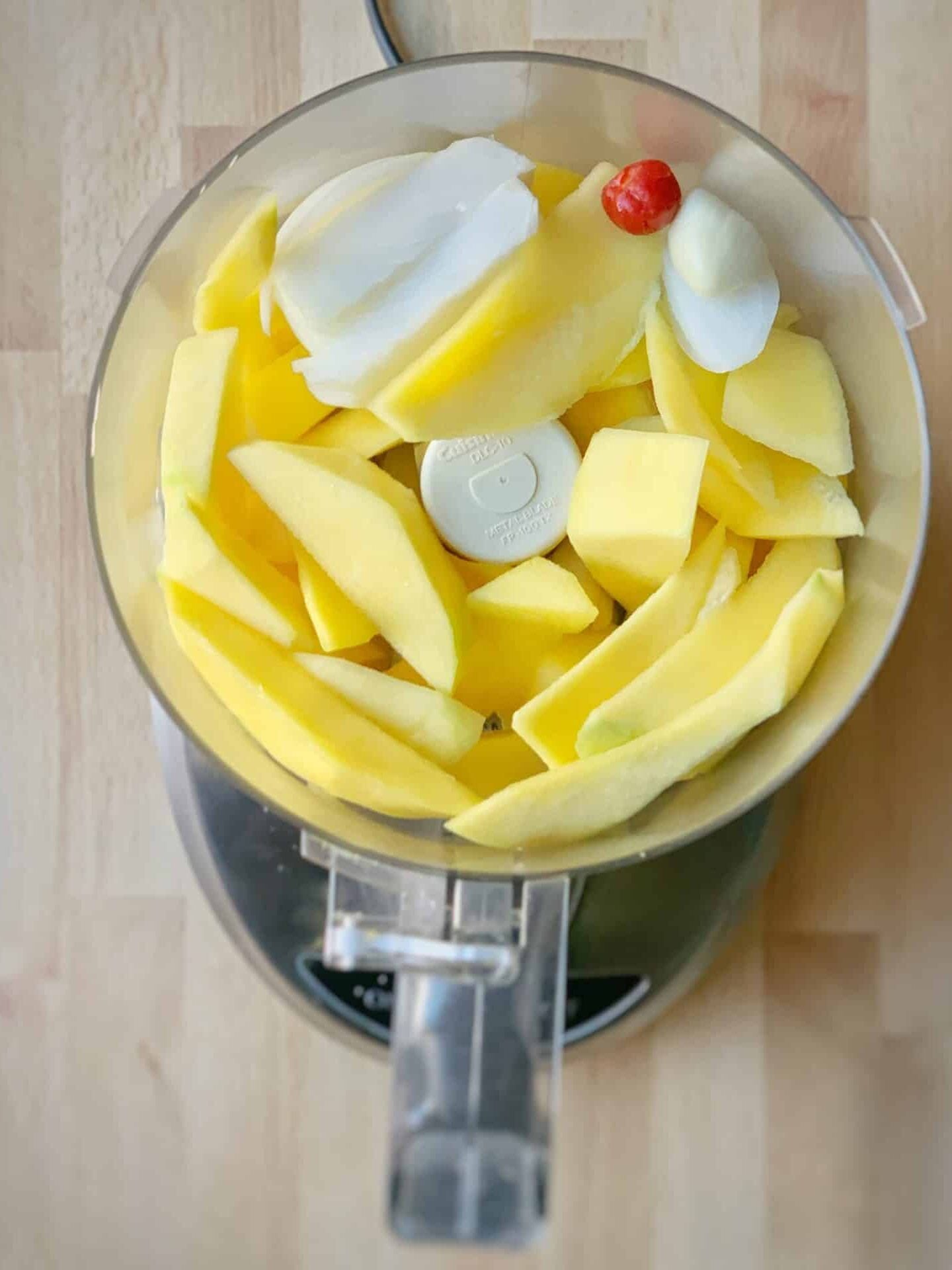 Ingredients for mango sour in a food processor