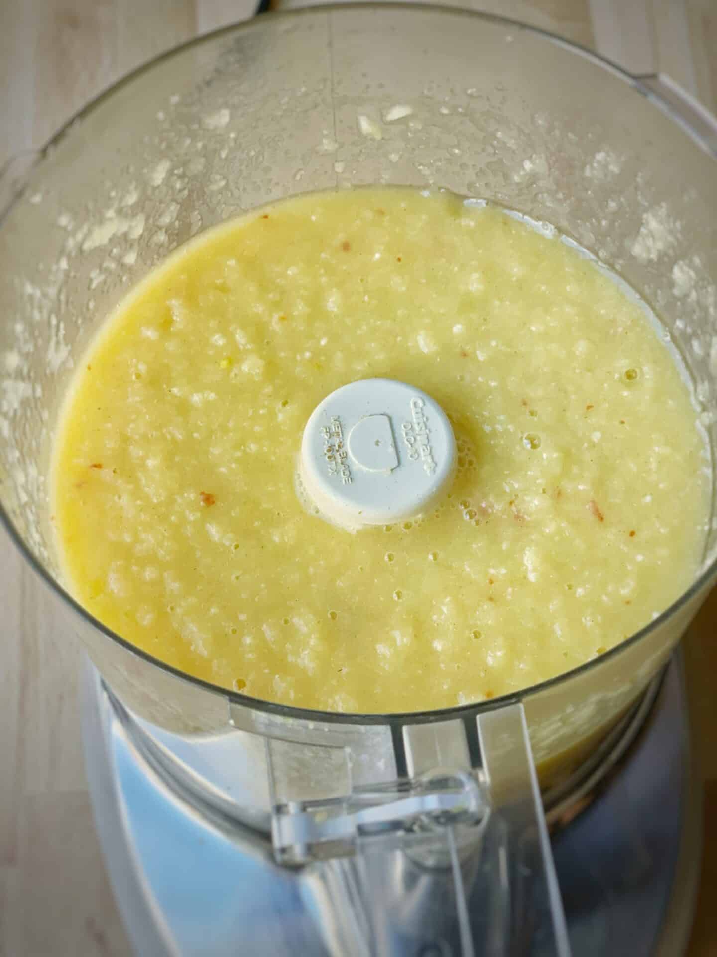 Ingredients for mango sour in a food processor after blending.