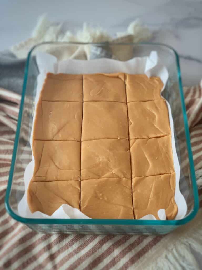 Fudge poured into a glass dish lined with parchment paper
