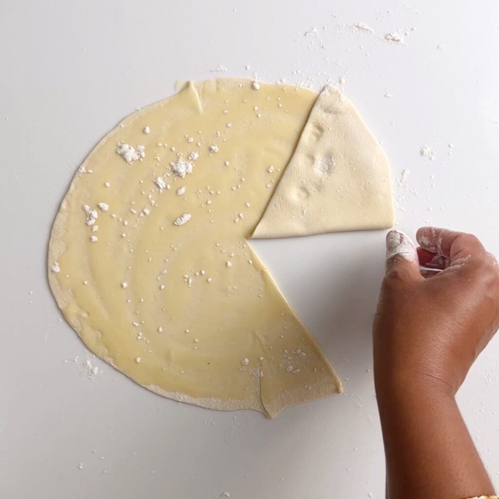 the flat round dough disk with oil and a sprinkle of flour with a slit and quarter fold