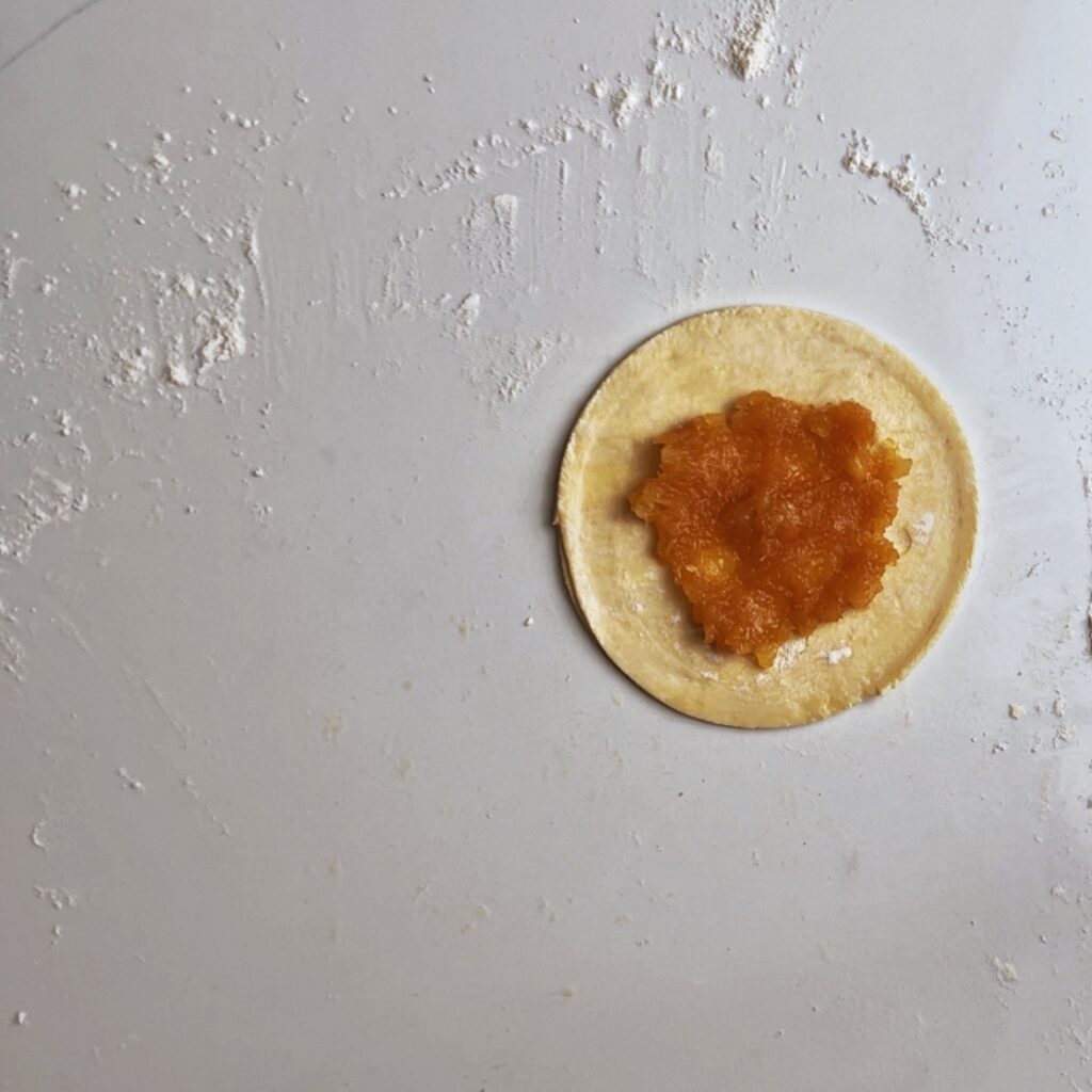 pineapple jam in the center of round pastry dough 