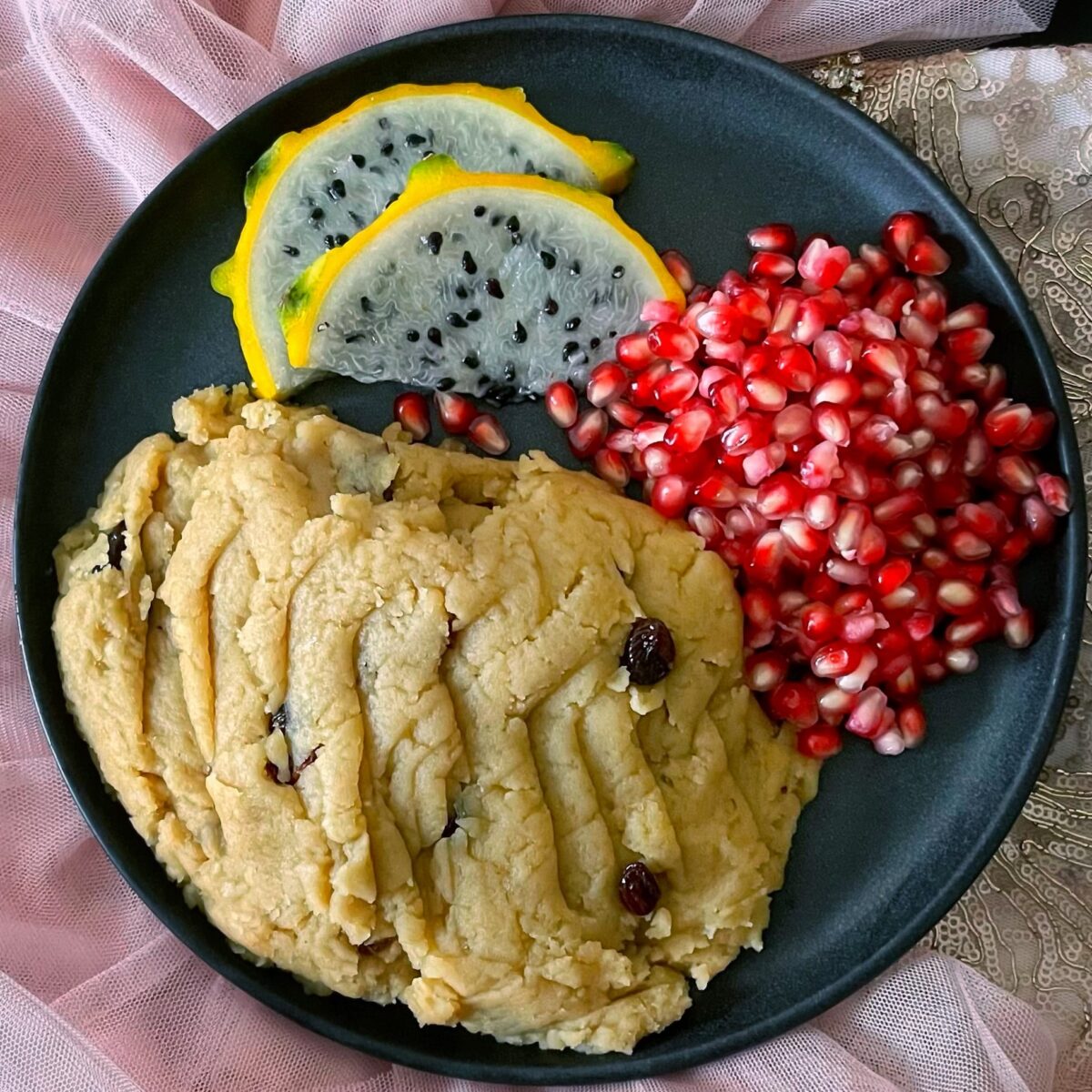 parasad, pomegranate and dragon fruit on a gray plate