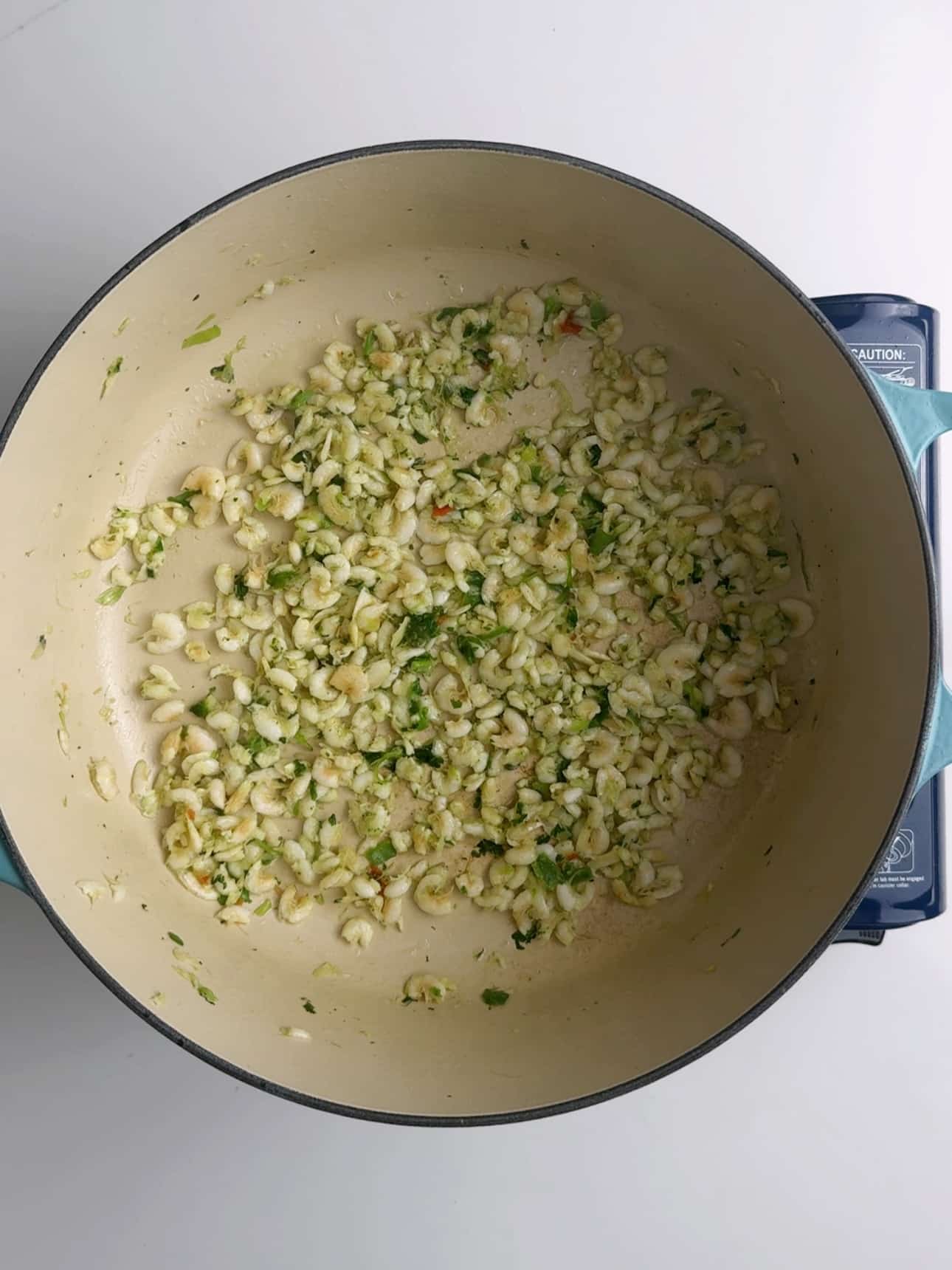 Cooking seasoned white belly shrimp in a skillet