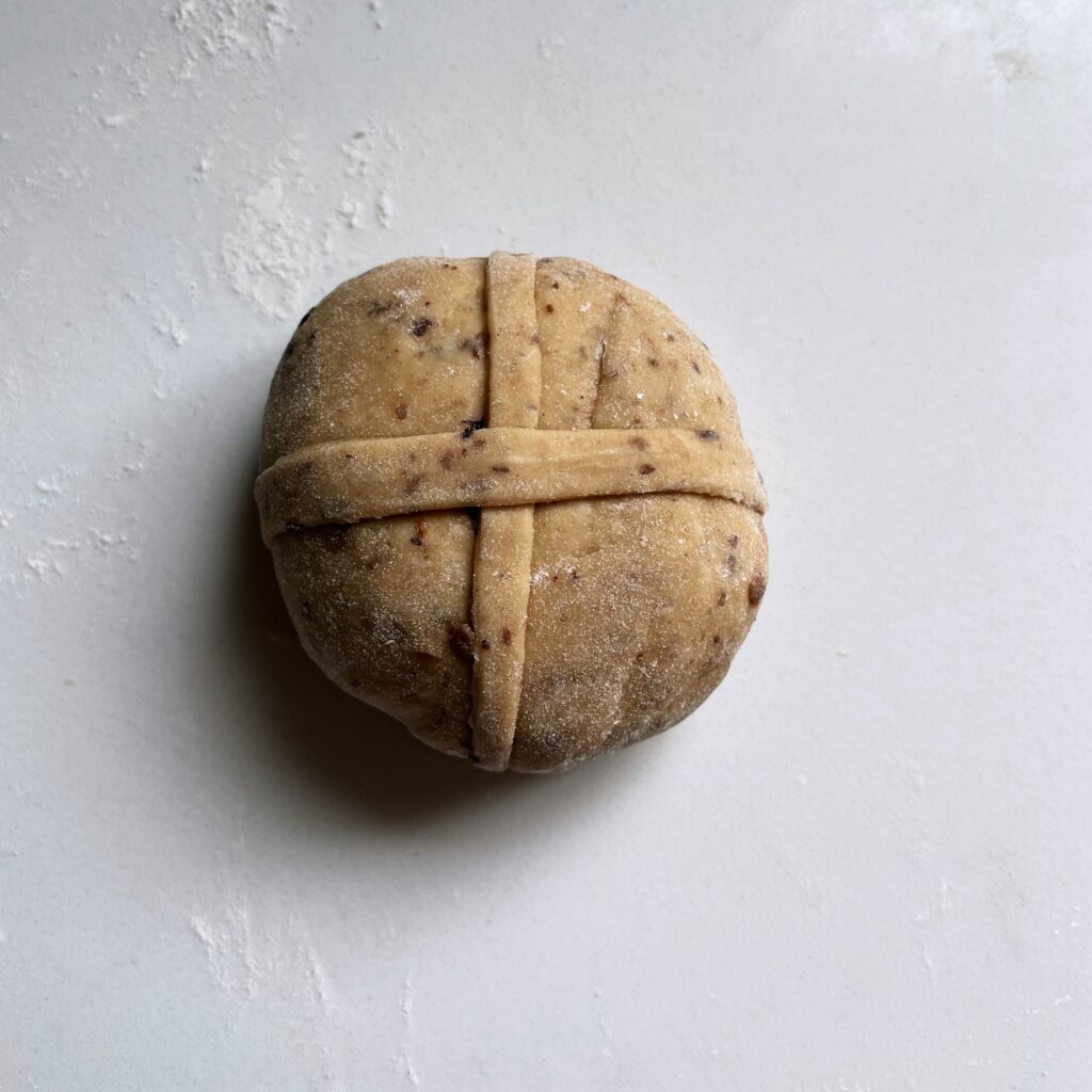 dough ball with dough cross on a white counter