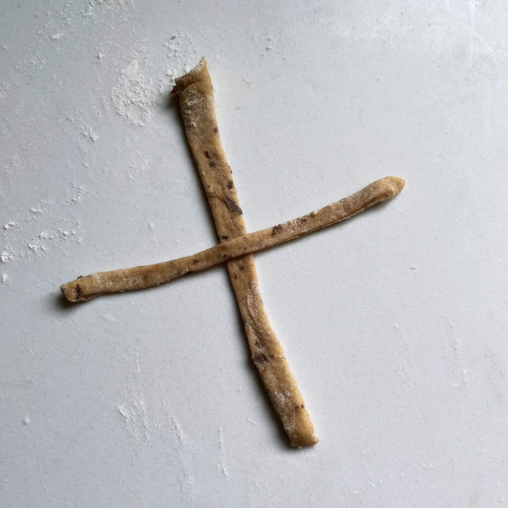 dough cross on a white floured counter