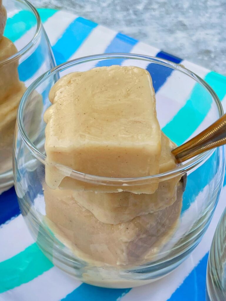 close up view of custard block in a cup with a spoon inserted