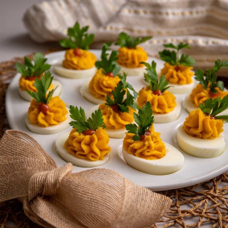 Guyanese stuffed eggs on a plate with some parsley garnish