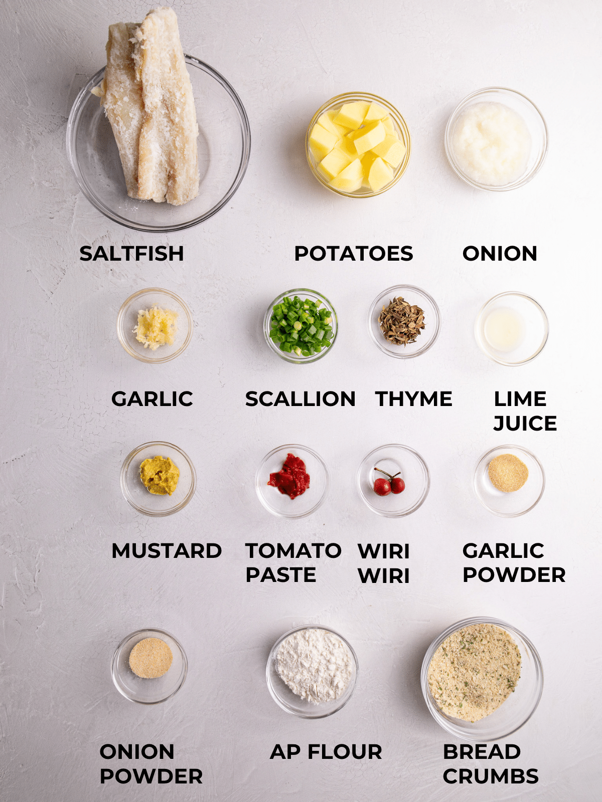 Ingredients for saltfish cakes measured out and labeled, including saltfish, potatoes, herbs, spices, and breadcrumbs”