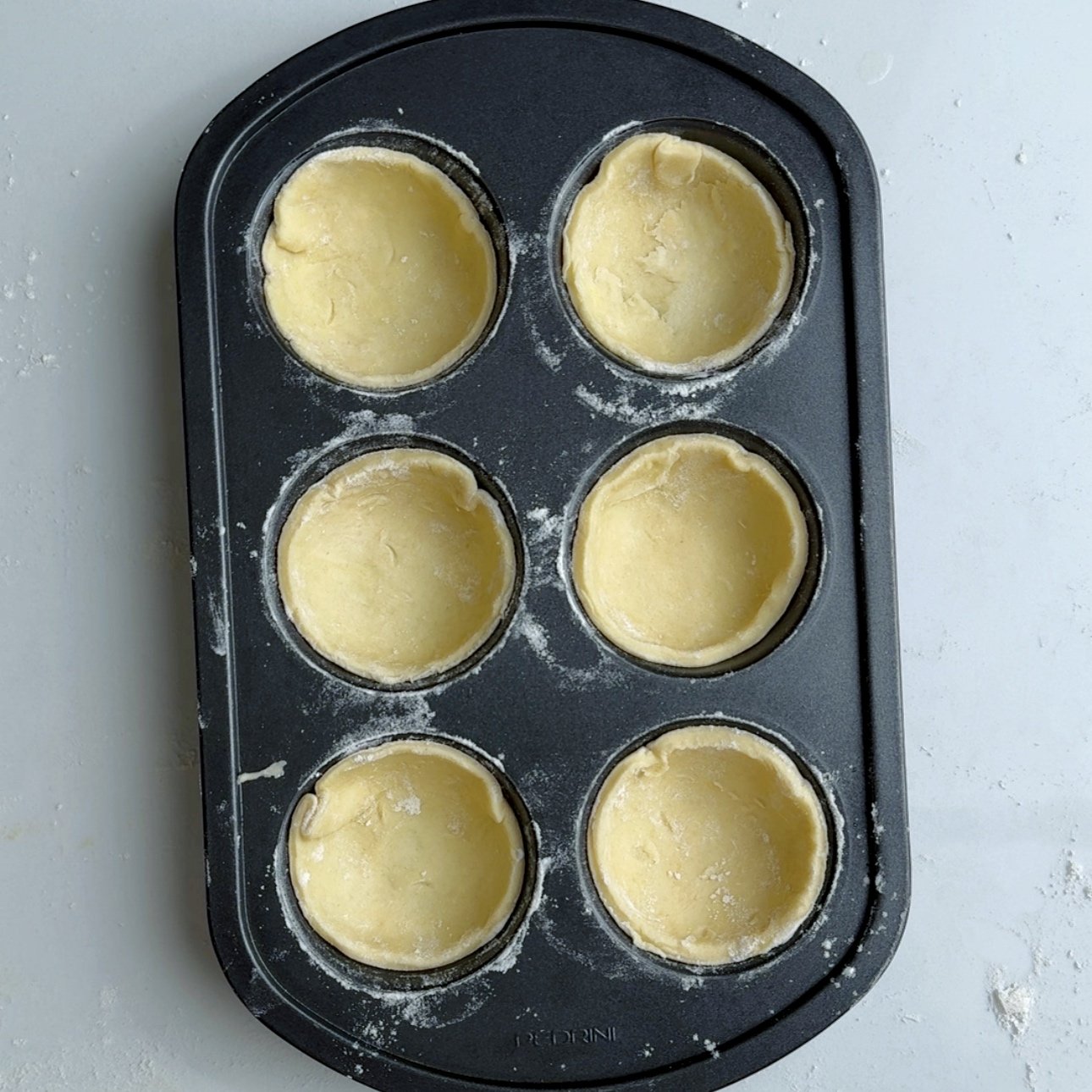 pastry shells stuffed into a 6 compartment muffin tin