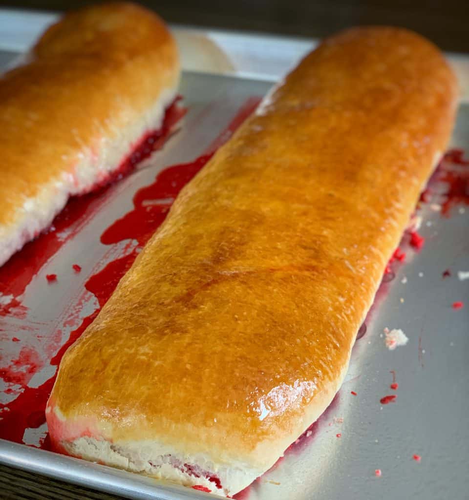 two baked salara rolls on a baking sheet