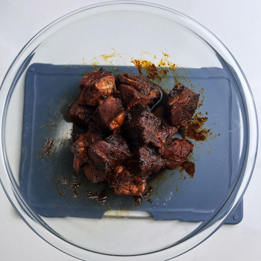 beef marinating in a glass bowl