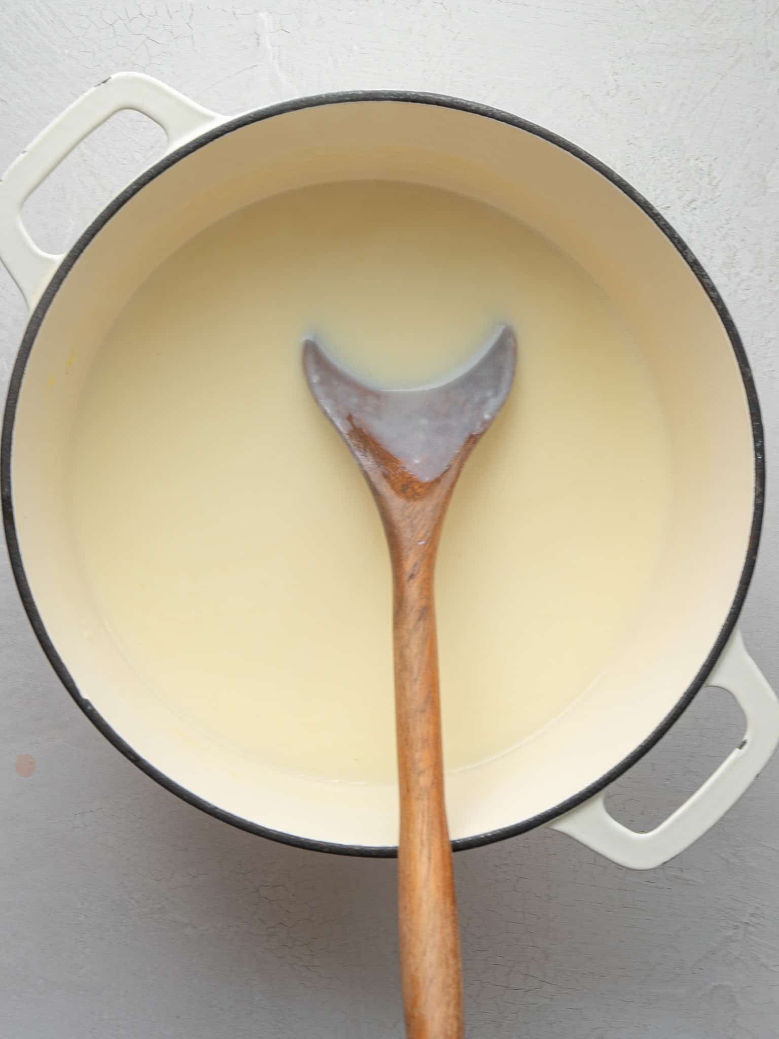 Warm milk stirred into the roux in a Dutch oven