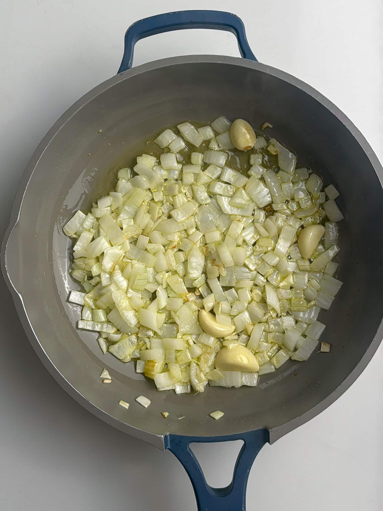 diced onions and garlic cooking in oil in a skillet