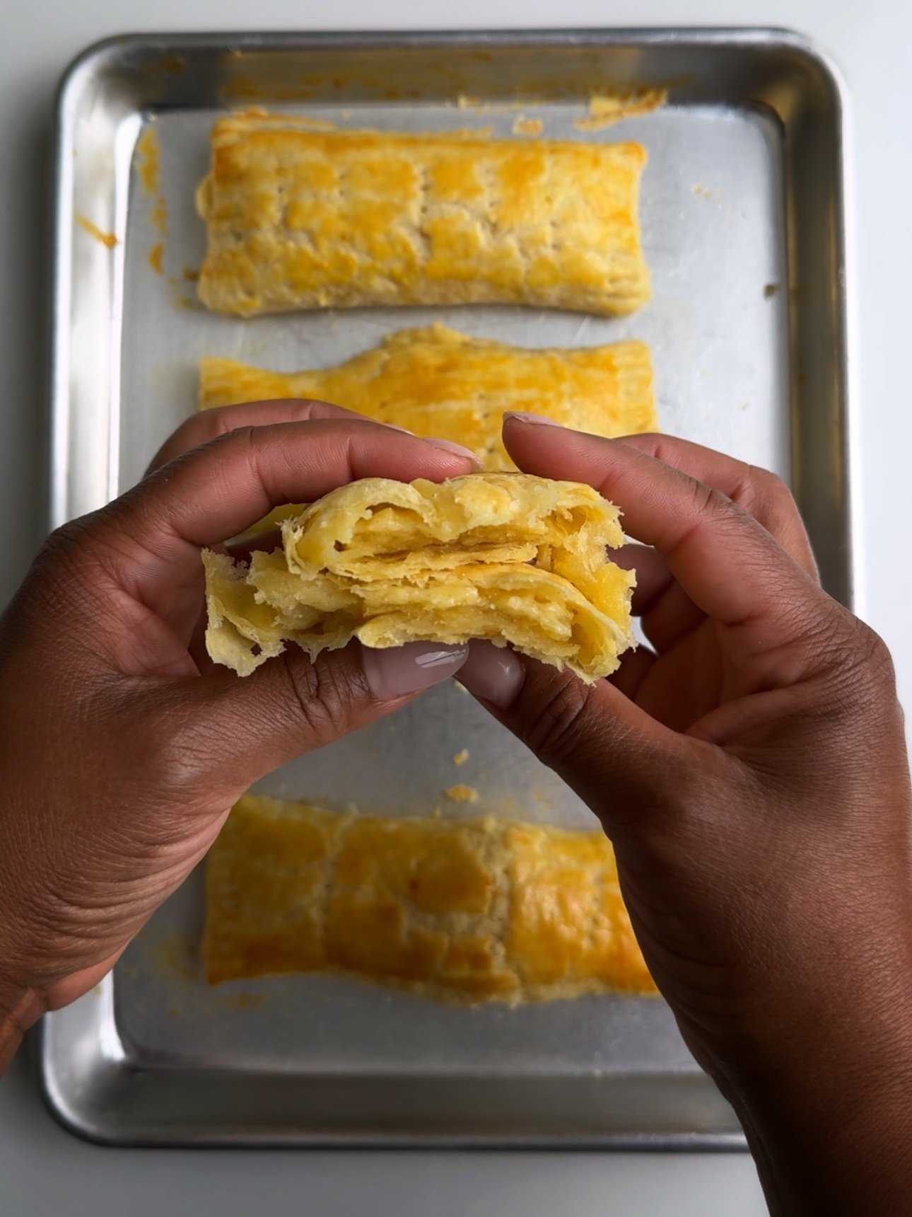 Cross section of a guyanese cheese roll showing all the flaky layers.