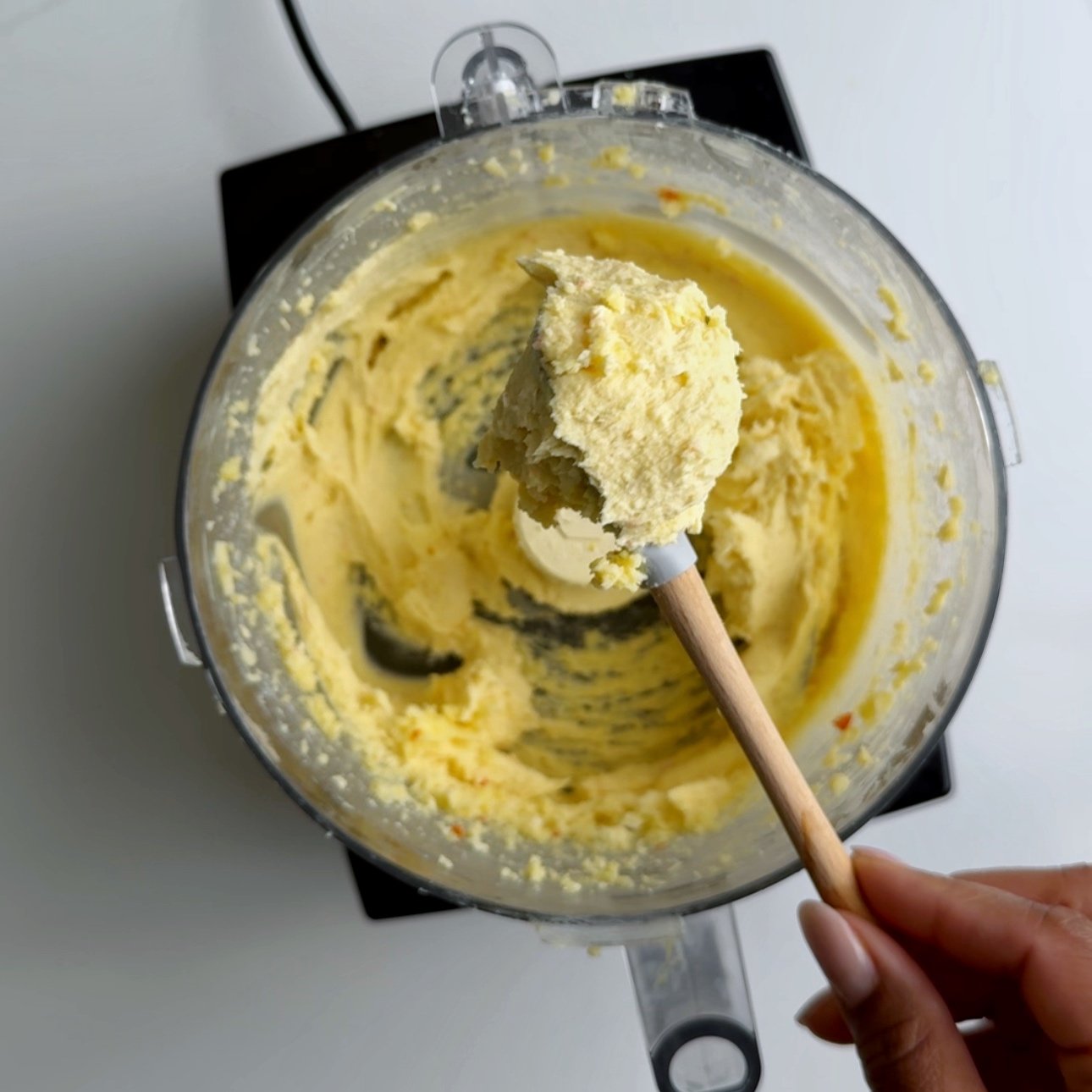 Blending cheese roll filling being scooped out of a food processor