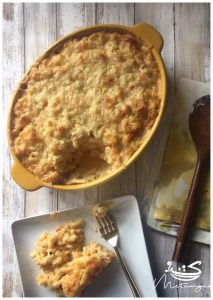 5 cheese macaroni and cheese in a casserole dish next to a plate with a serving
