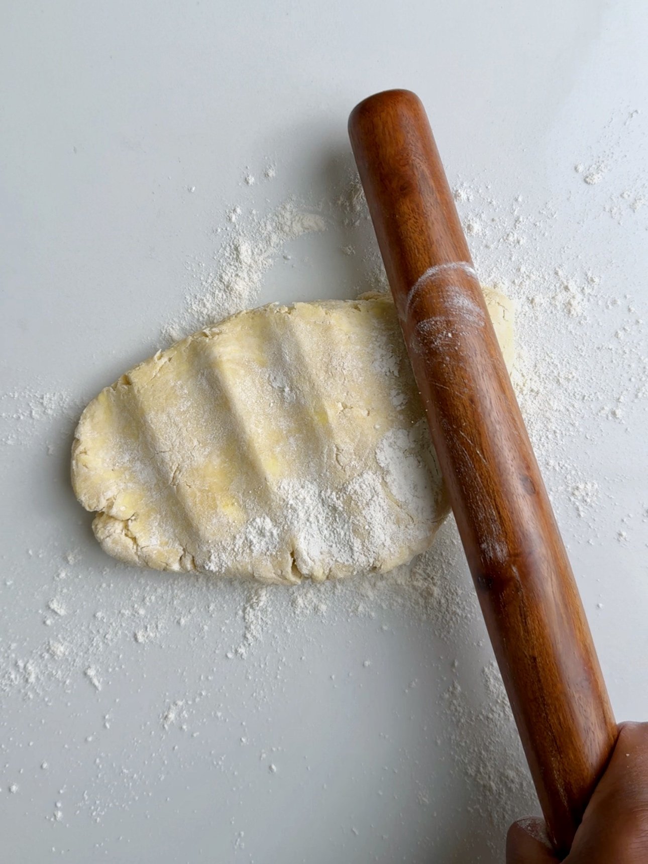 Tapping pastry dough with a rolling pin