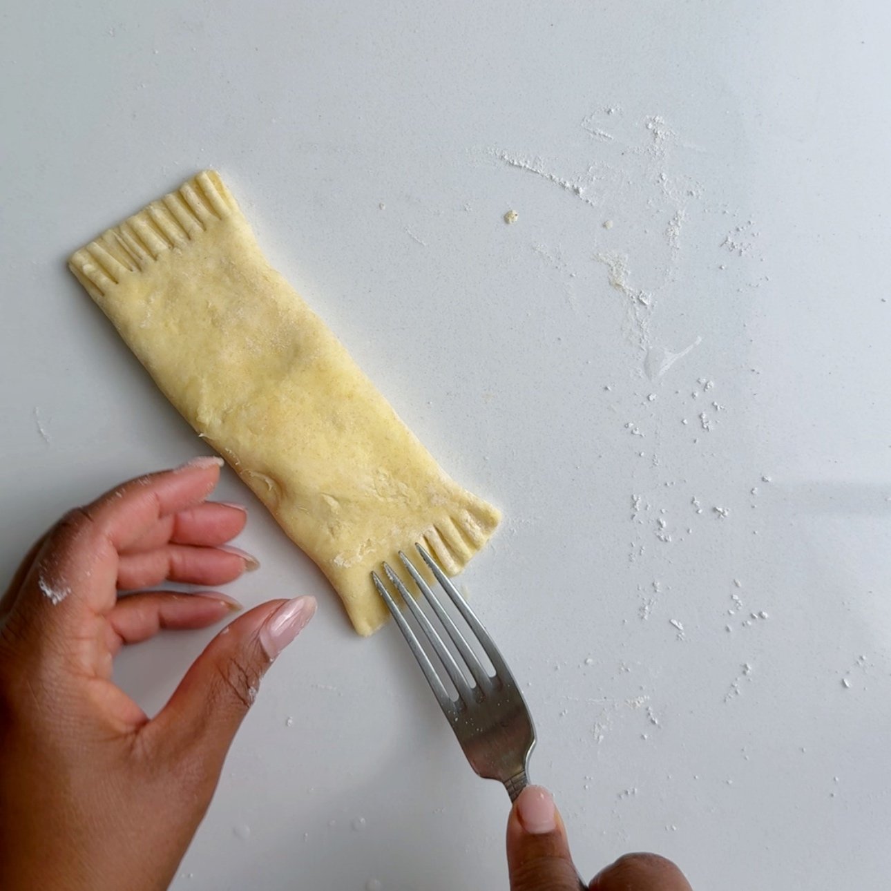 crimping the edge of the cheese rolls with a fork