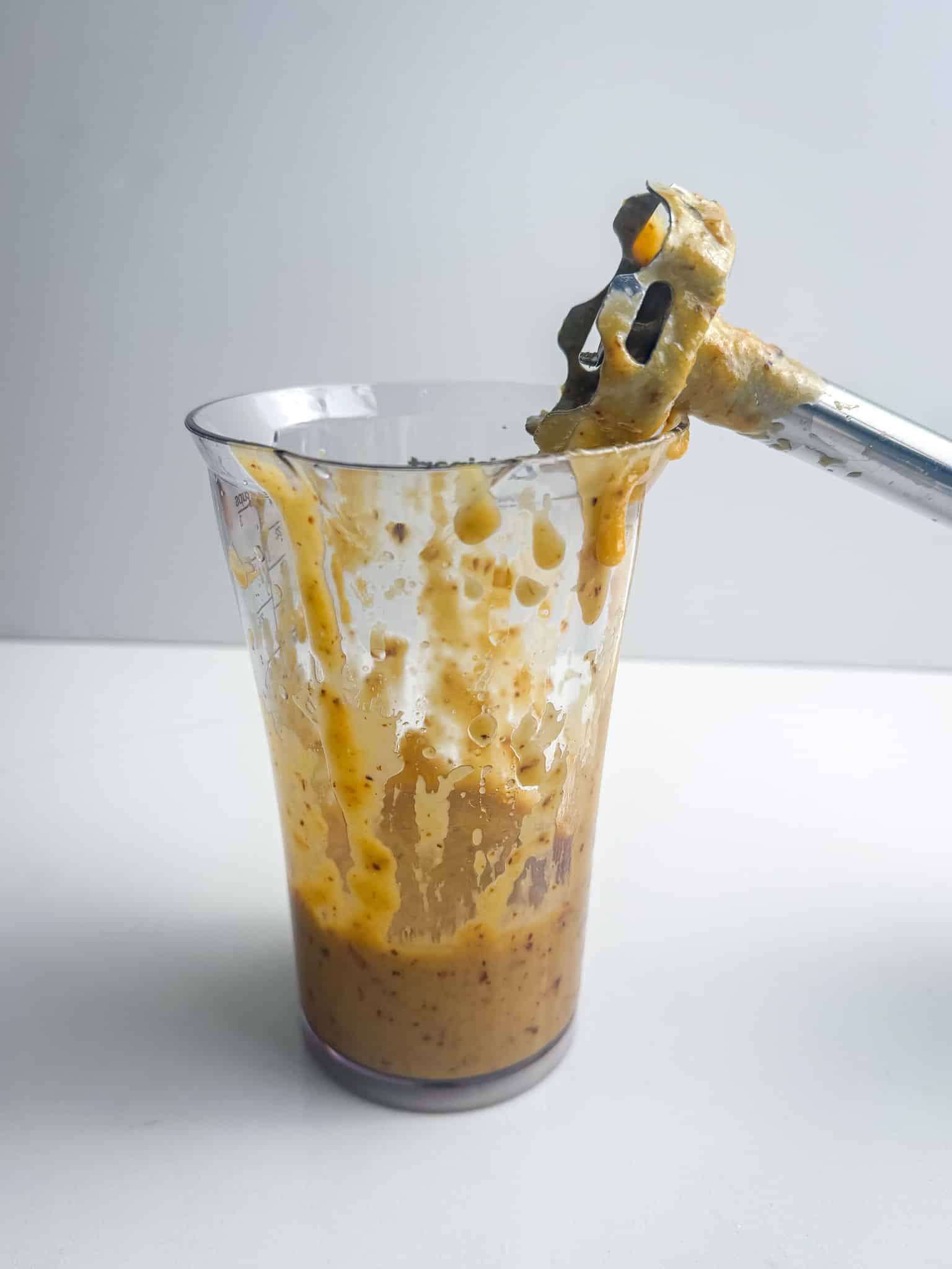 caramelized onion dressing being blended in a measuring cup