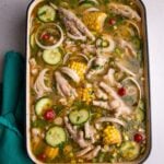 Chicken foot souse plated in a large rectangular cast iron dish with a teal napkin to the bottom left.