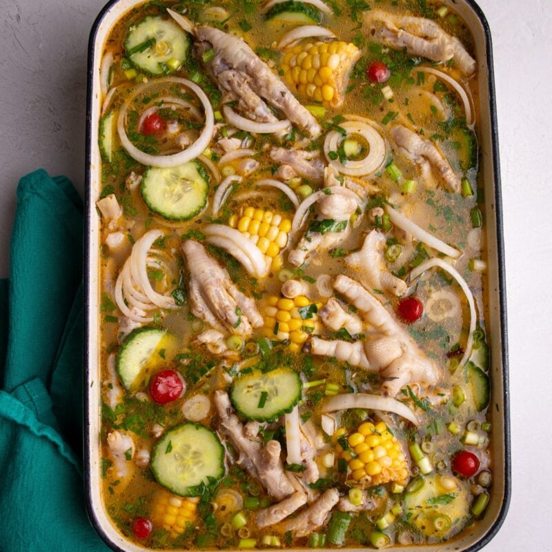 Chicken foot souse plated in a large rectangular cast iron dish with a teal napkin to the bottom left.