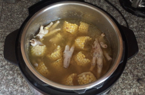 an instant pot full of chicken foot and corn