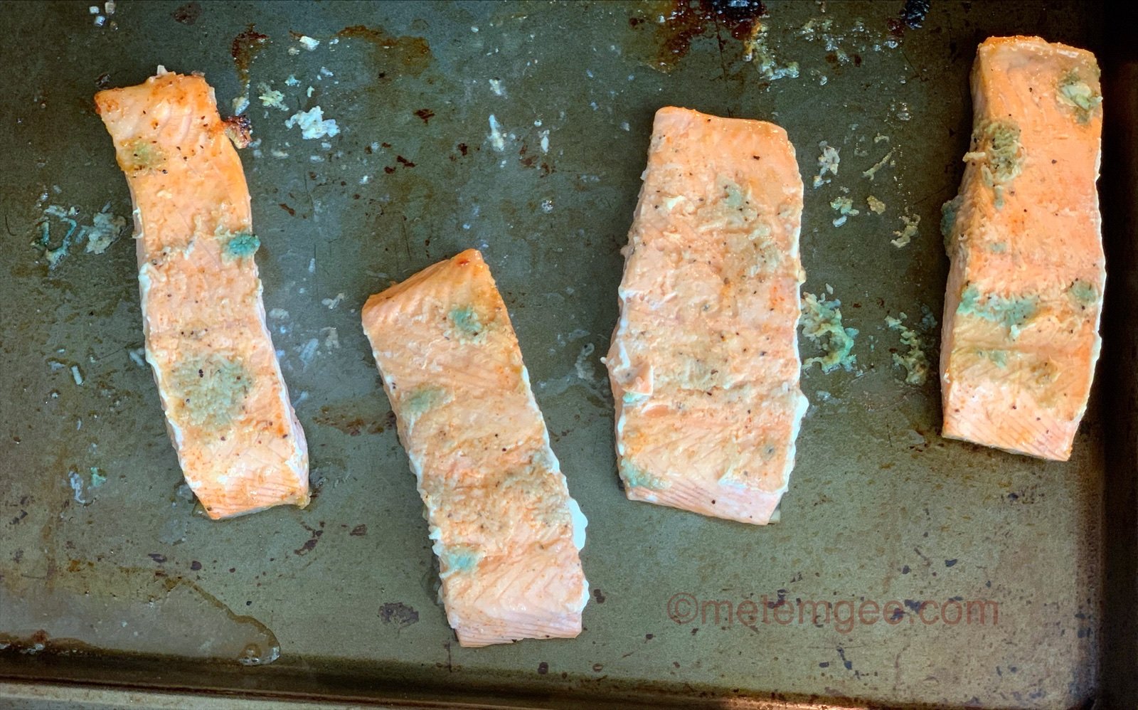 skin side down salmon filets on a baking sheet