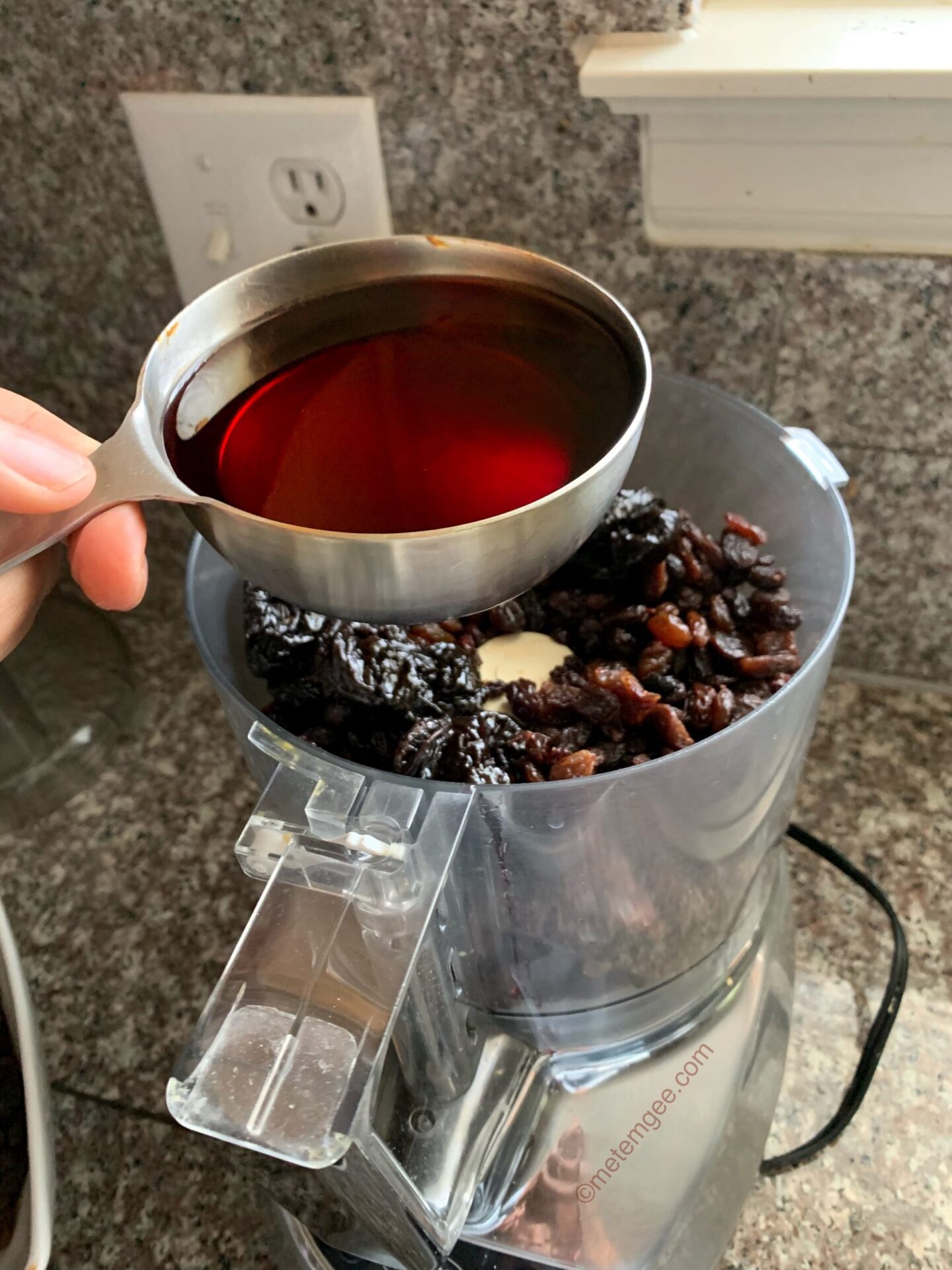 adding red wine to dried fruit in the processor for soaked fruits recipe