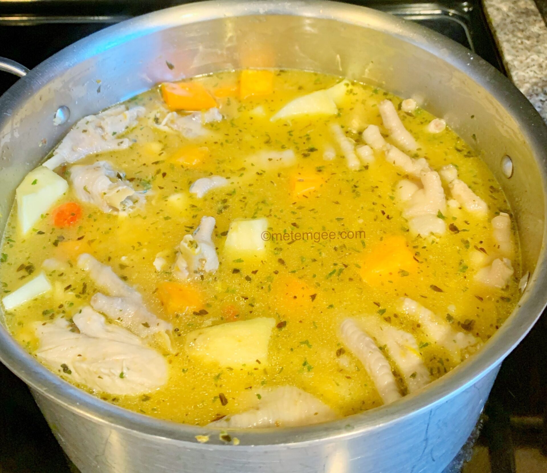 a large pot of chicken foot soup in the process of cooking