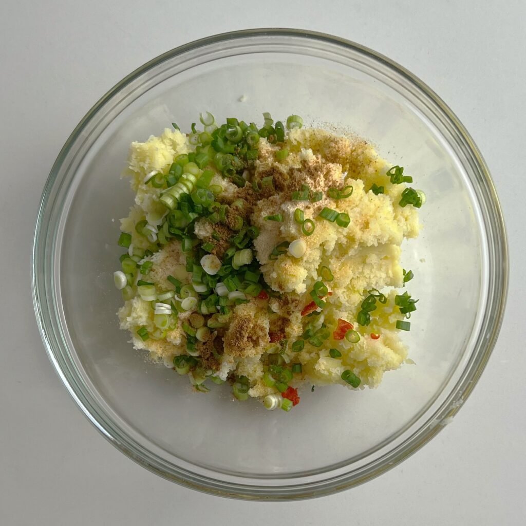 bowl of mashed potatoes with seasoning for aloo paratha