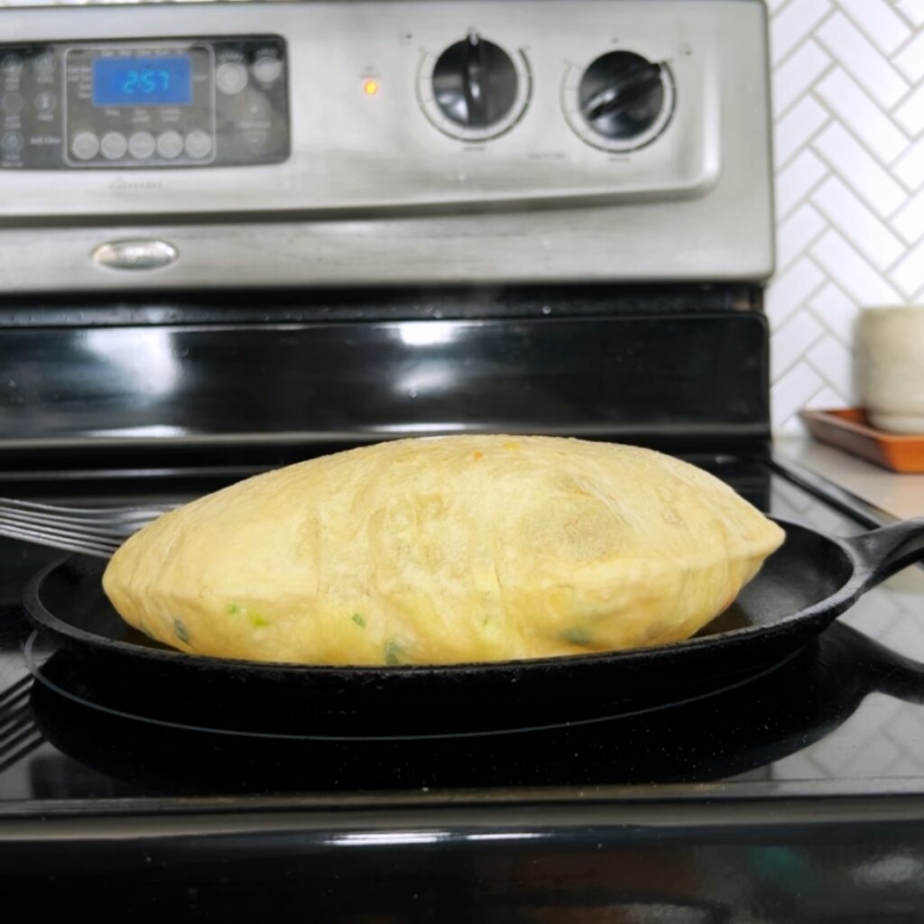 puffed up aloo paratha in a skillet