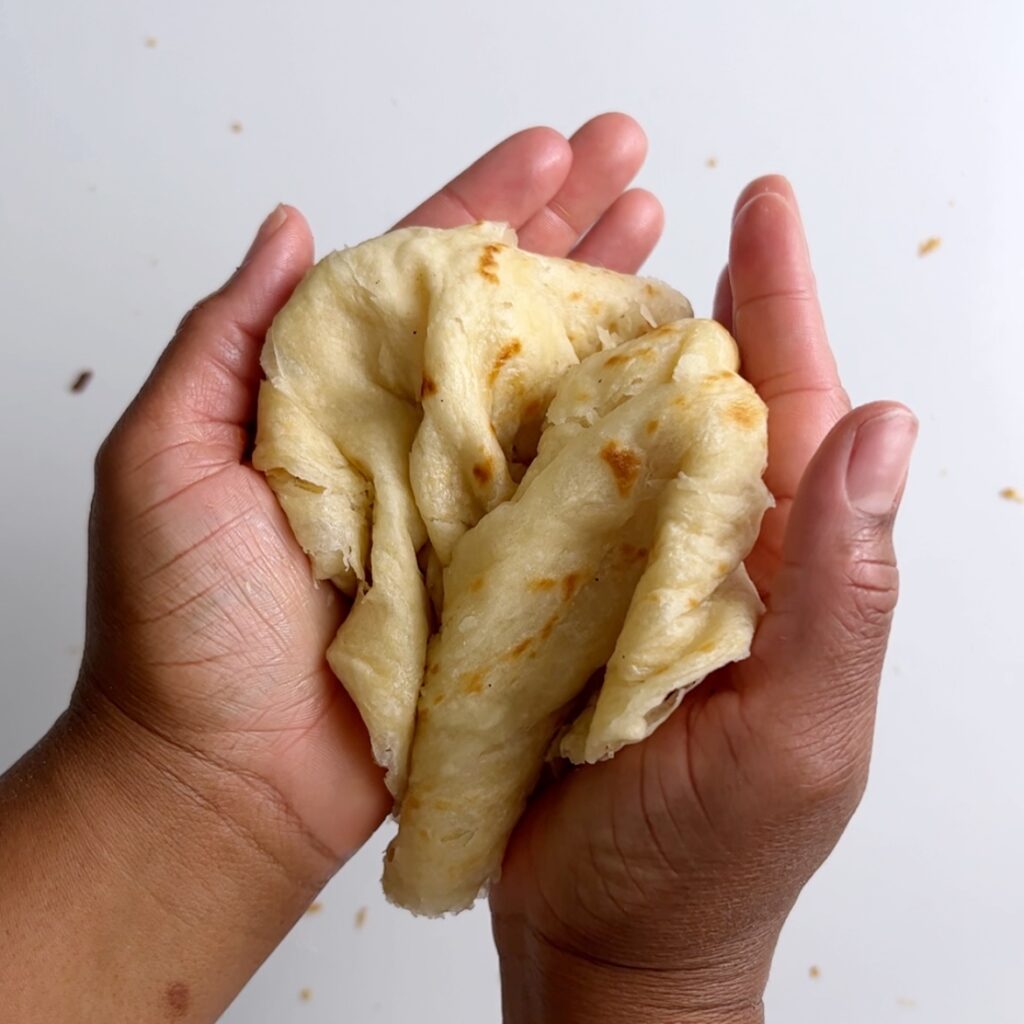 roti dough half way compressed between palms