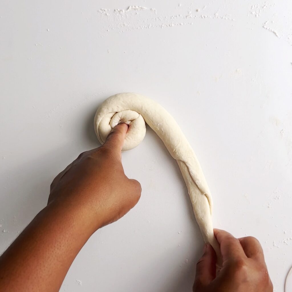 swirling the dough around your finger to form a circular dough ball