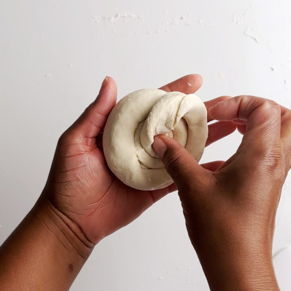 Tucking the end of the log into the bottom of the roti ball or loi