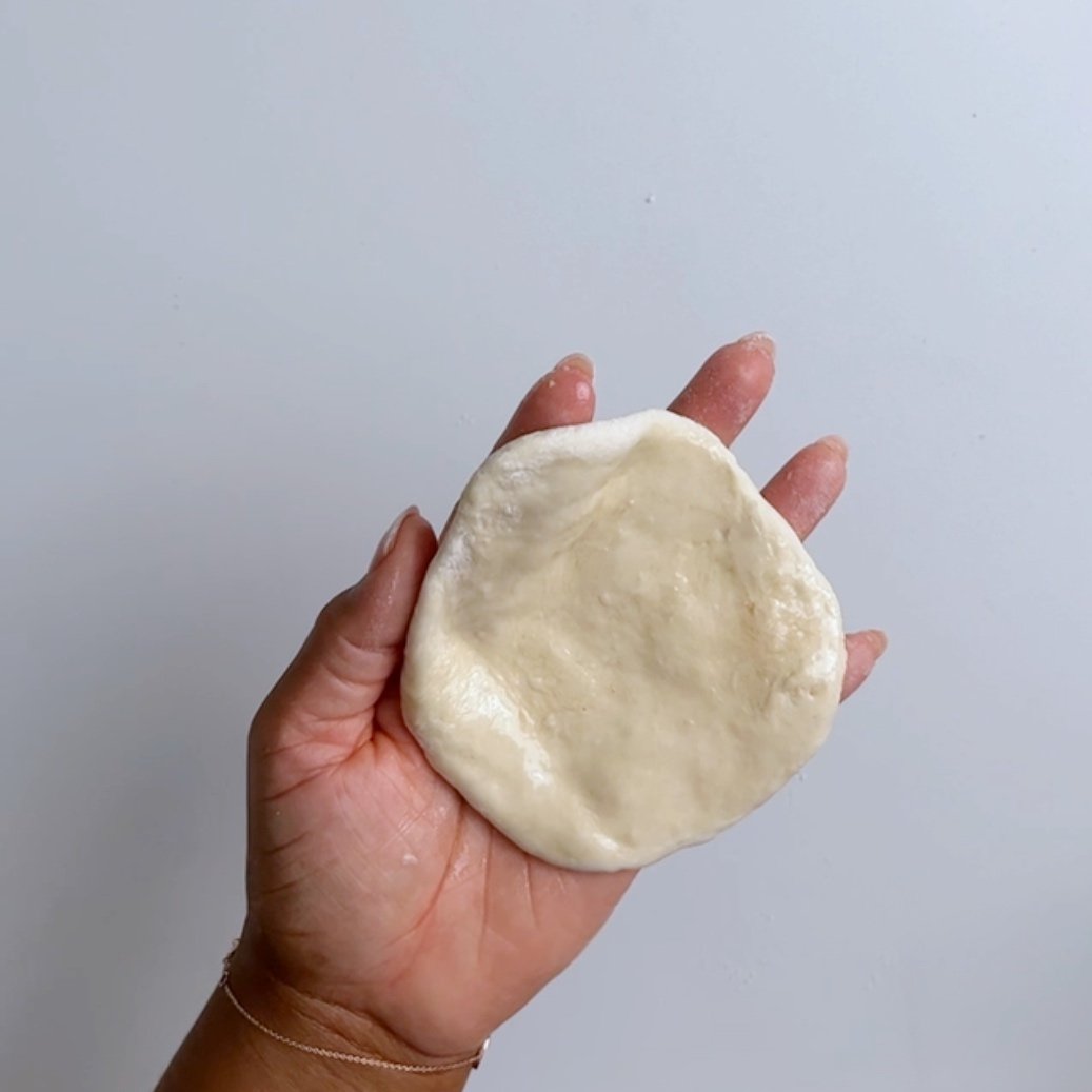 flattened dough in hand