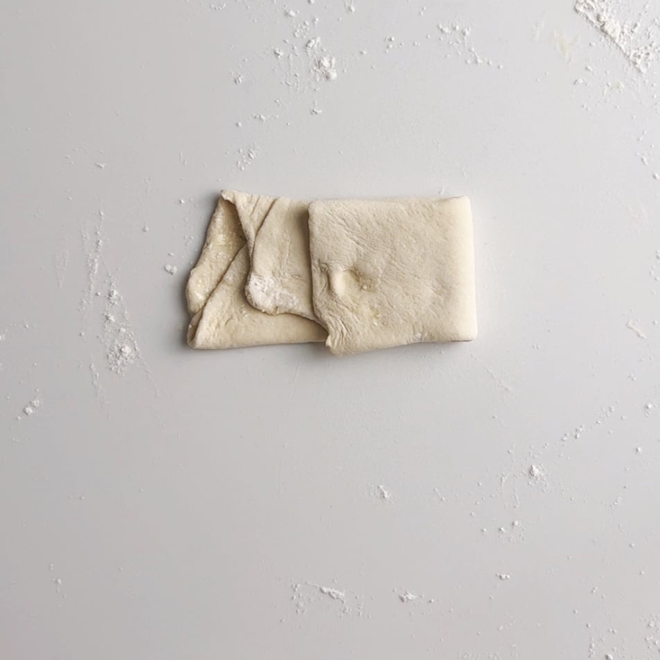 Roti dough folded into a half fold to form a squaree