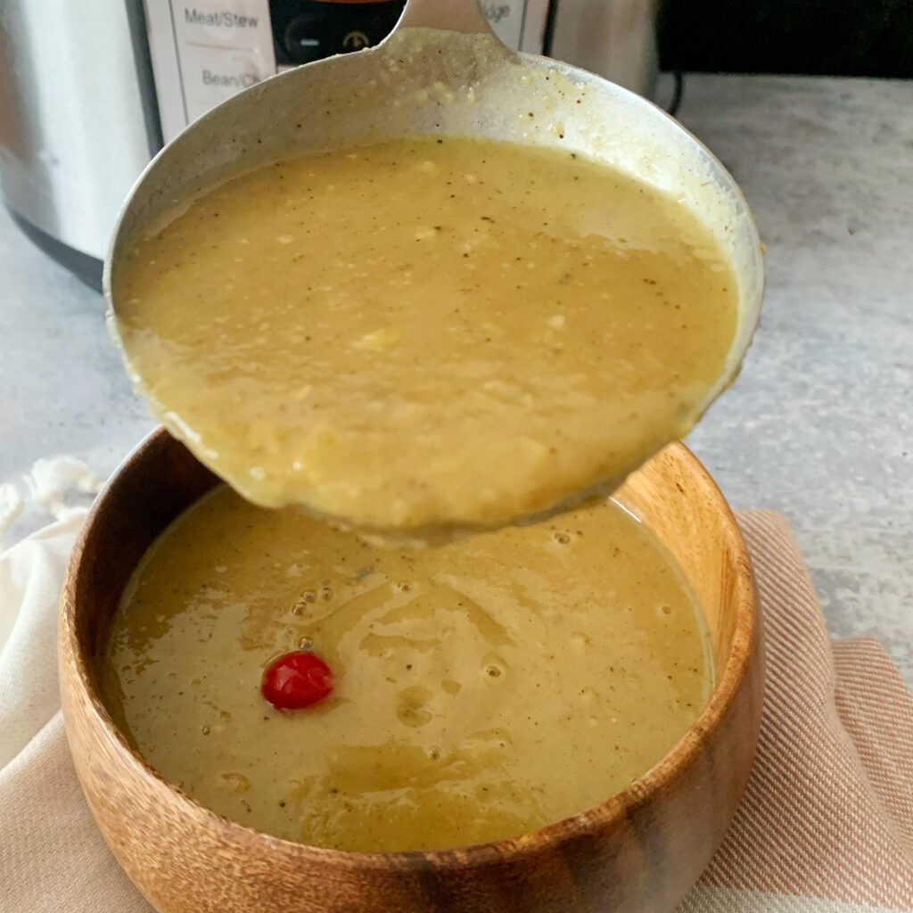 Dhal in a ladle being poured into a wooden bowl