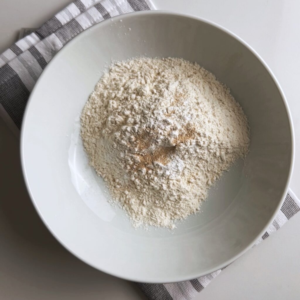 overhead view of dry ingredients for aloo paratha dough in a bowl