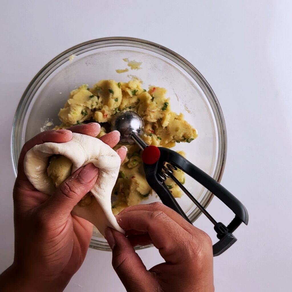 Folding potato filling into dough