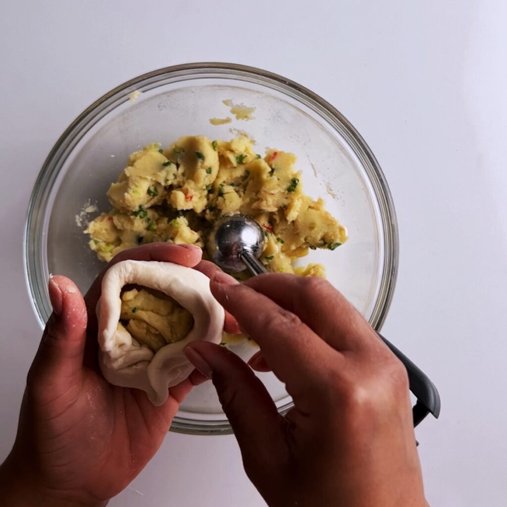 Folding potato filling into dough