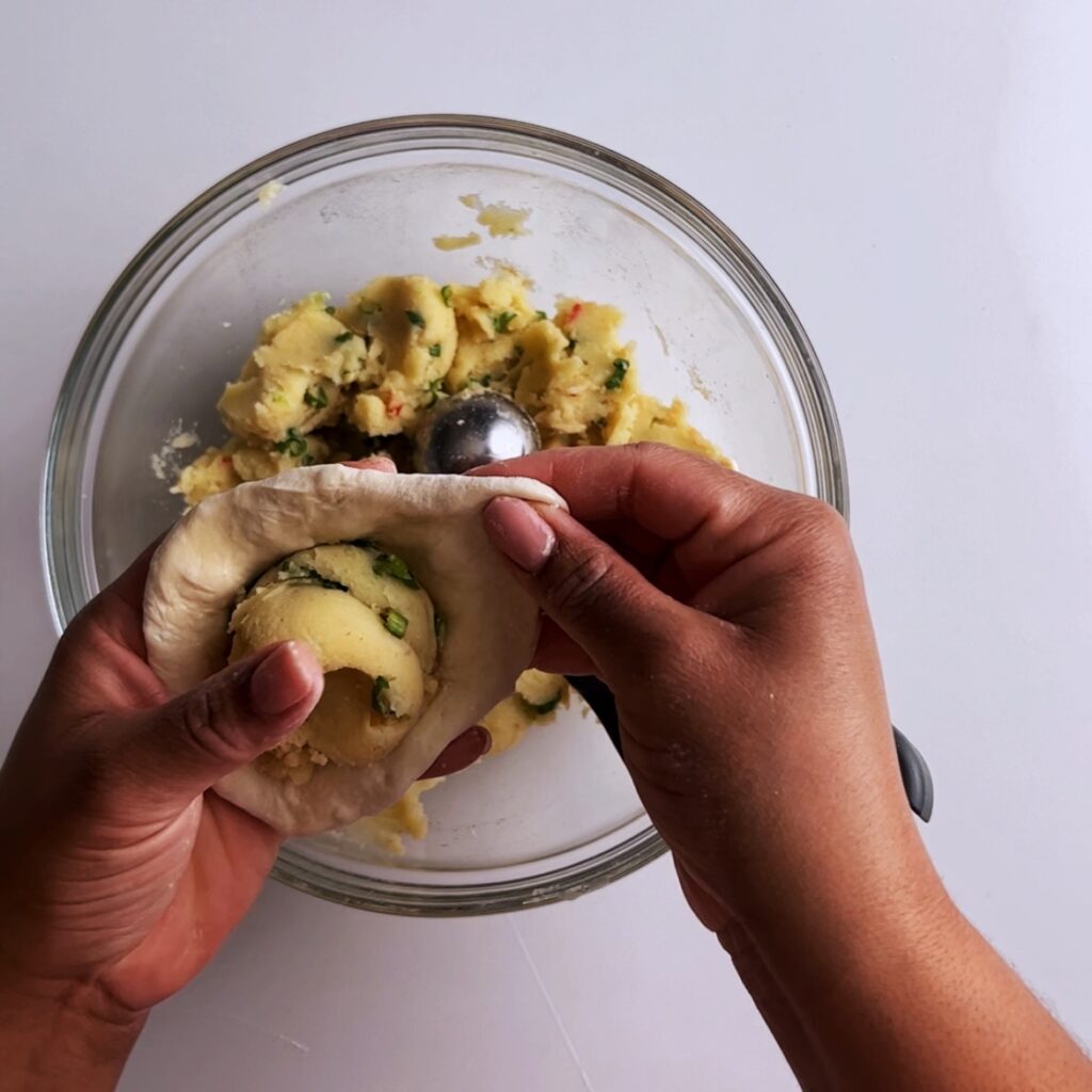 Folding potato filling into dough